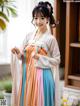 A woman in a colorful hanbok is posing for a picture.