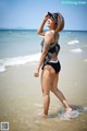 A woman in a black and white bathing suit standing in the ocean.